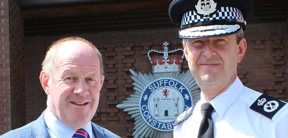 Chief and PCC outside police HQ in front of Constabulary crest