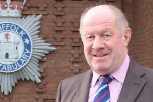 The PCC standing in front of the Constabulary crest